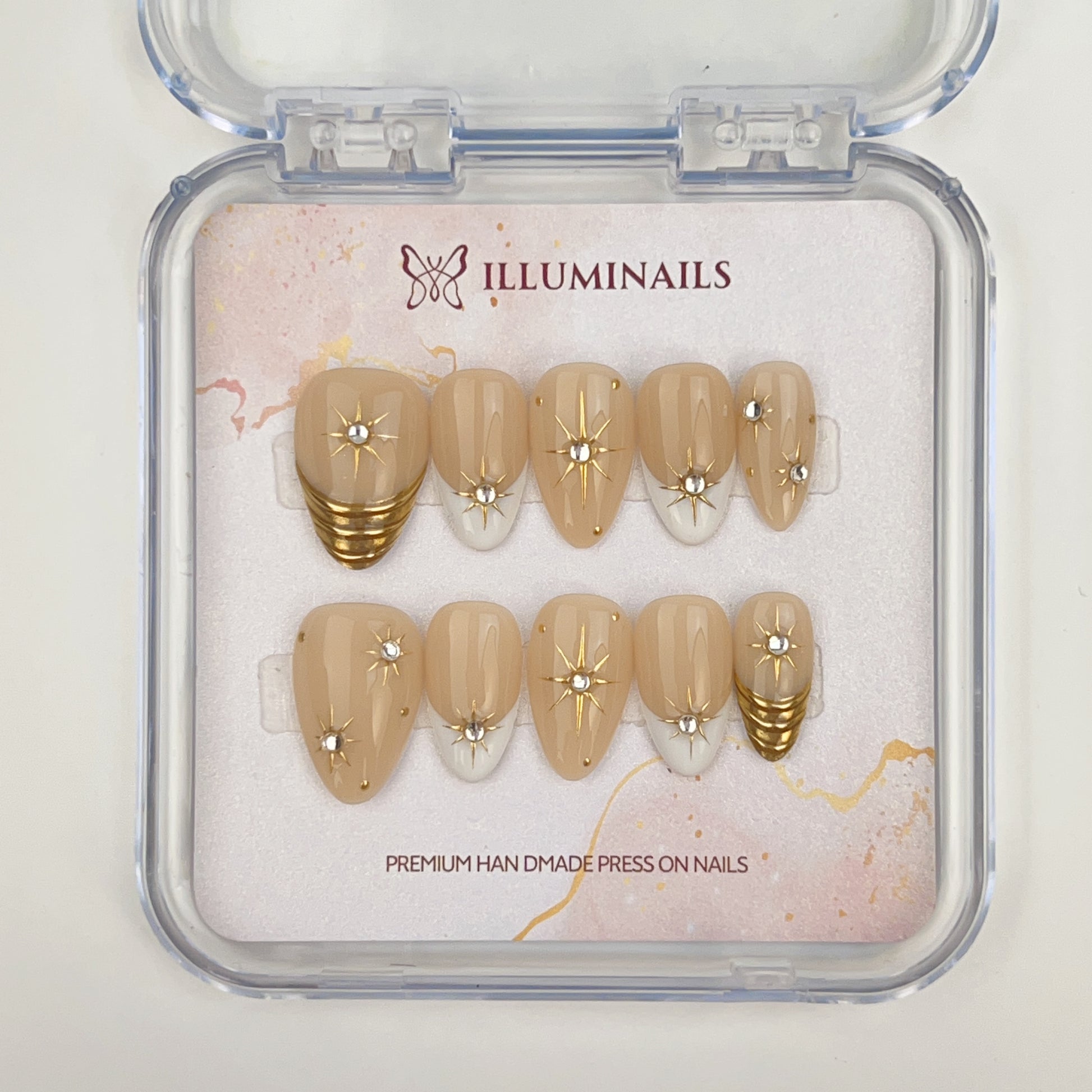 Set of press-on nails with gold and beige design in a clear case, featuring the brand 'Illuminails'.