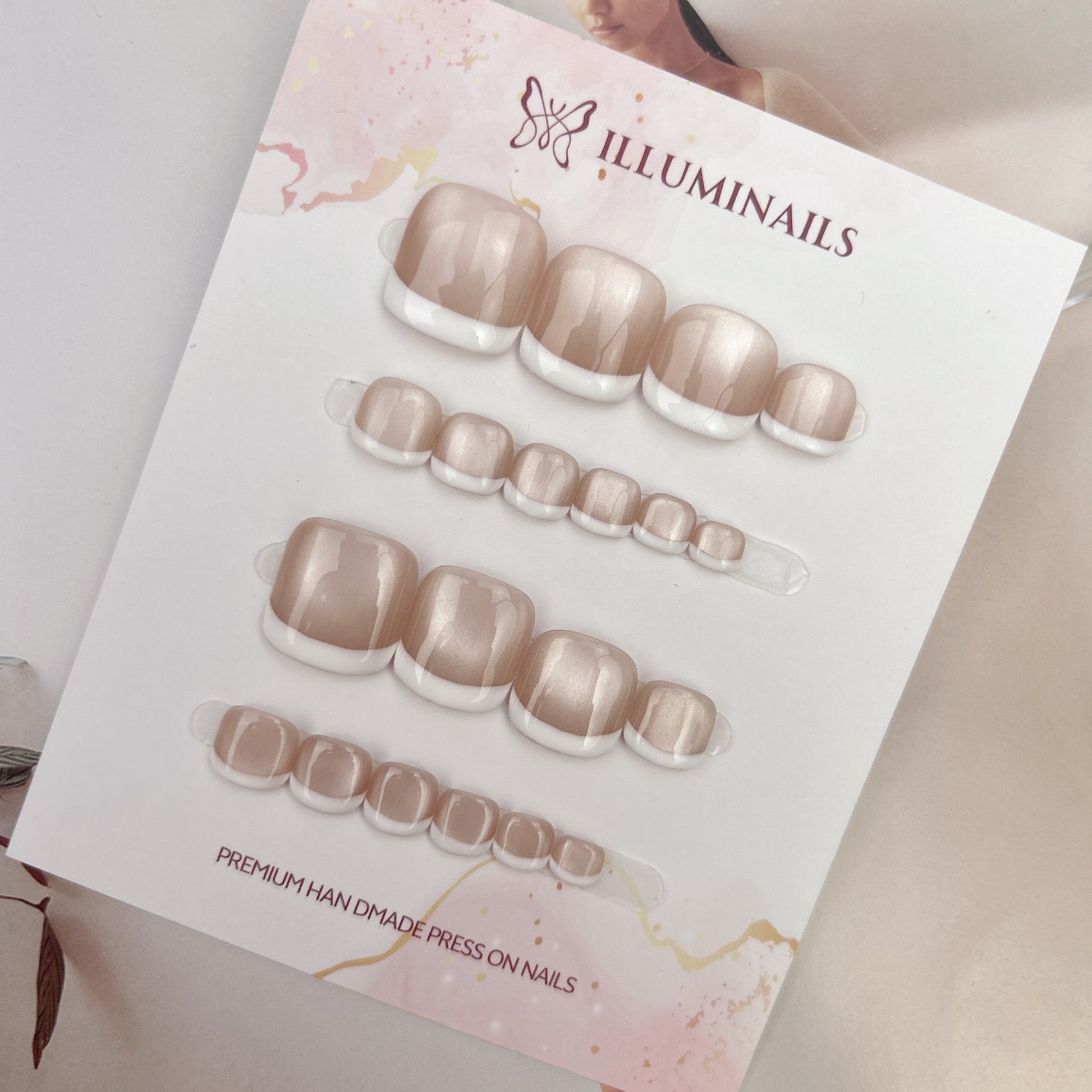 White French cat eye press-on toenails photographed on a neutral lifestyle background